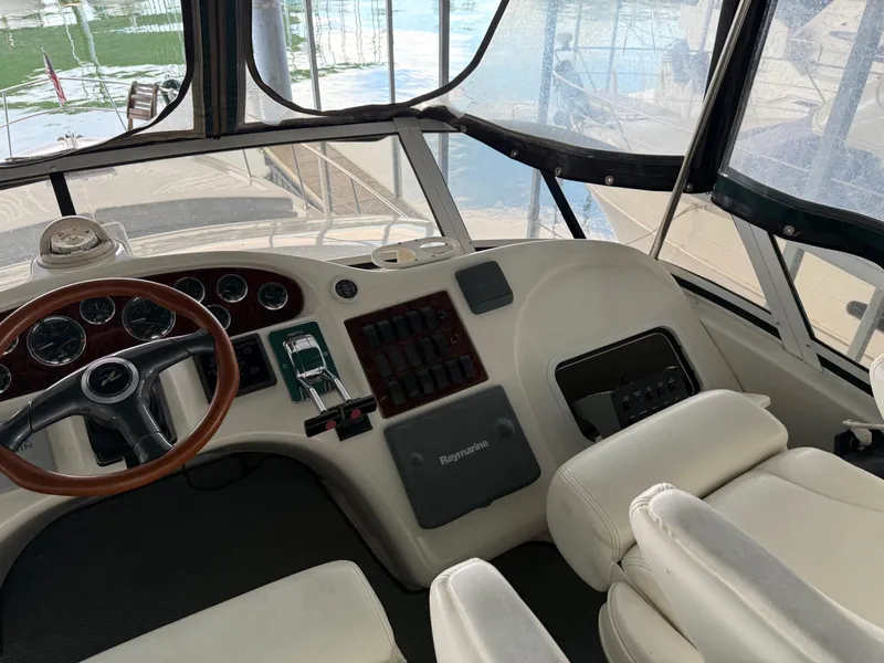 Slide: The Image of 1999 Sea Ray 400 Sedan Bridge helm with steering wheel and control panel. - 42