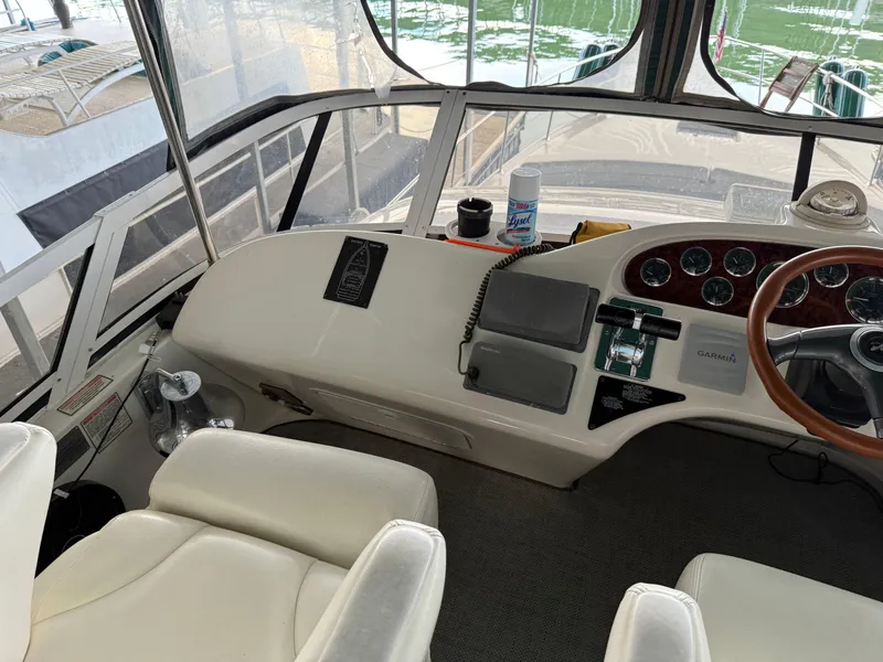 Slide: The Image of 1999 Sea Ray 400 Sedan Bridge helm with steering wheel, gauges, and navigation equipment. - 44