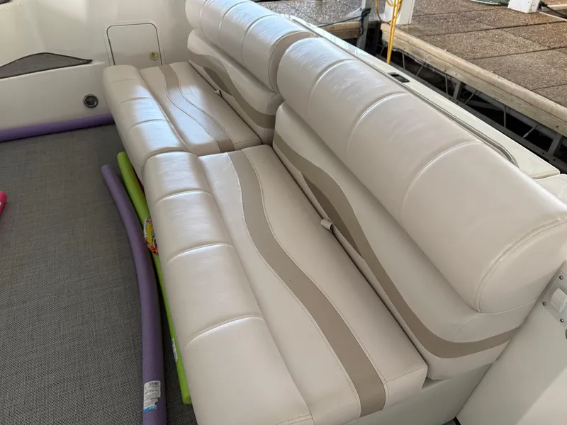 Slide: The Image of White leather seating on 1999 Sea Ray 400 Sedan Bridge yacht, with pool noodles nearby. - 47