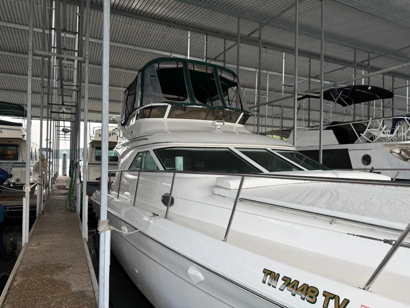 Slide: The Image of 1999 Sea Ray 400 Sedan Bridge yacht docked in a covered marina. - 48
