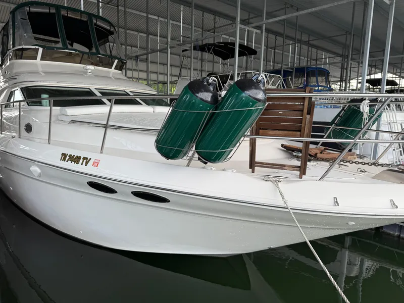 Slide: The Image of 1999 Sea Ray 400 Sedan Bridge yacht docked in a covered marina. - 49