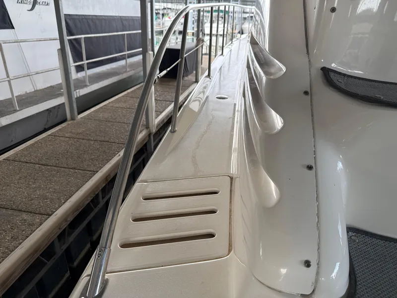 Slide: The Image of 1999 Sea Ray 400 Sedan Bridge yacht deck with railing, docked at marina. - 7