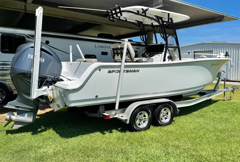 Slide: The Image of 2022 Sportsman Open 242 Center Console boat on trailer, parked on grass. - 4