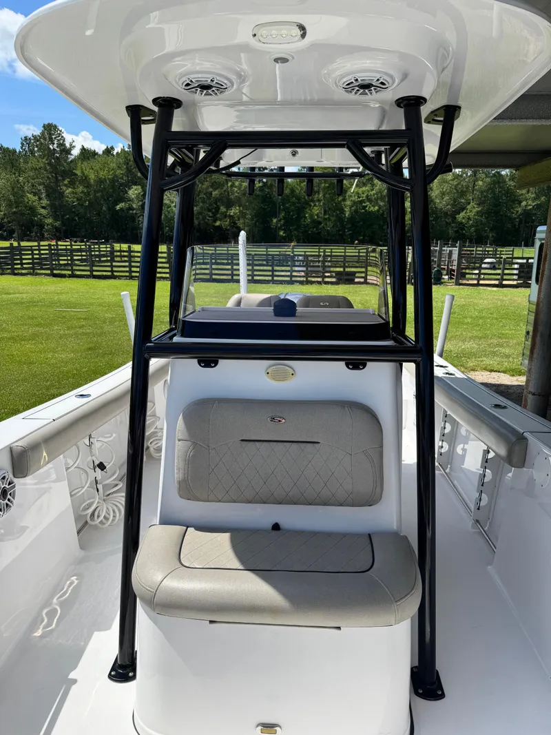 Slide: The Image of 2022 Sportsman Open 242 Center Console boat with seating and T-top, parked outdoors. - 5