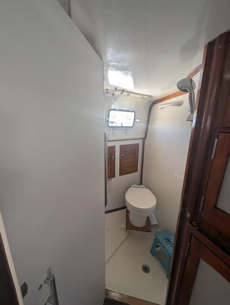 Slide: The Image of Compact bathroom in 1976 Mason COHORT II boat with toilet, window, and wooden accents. - 11