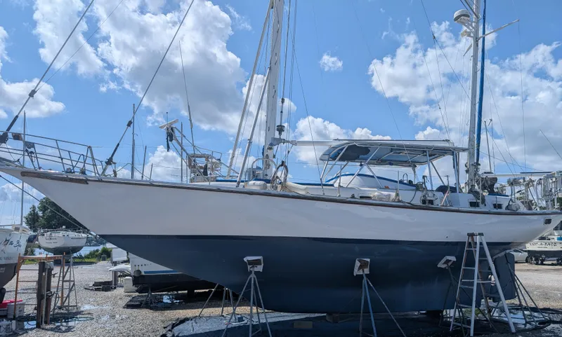 Slide: The Image of 1976 Mason COHORT II sailboat on stands under a bright blue sky with clouds. - 18