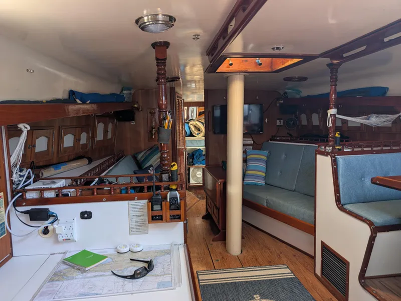 Slide: The Image of Interior of a 1976 Mason COHORT II boat with wooden furnishings and seating area. - 2