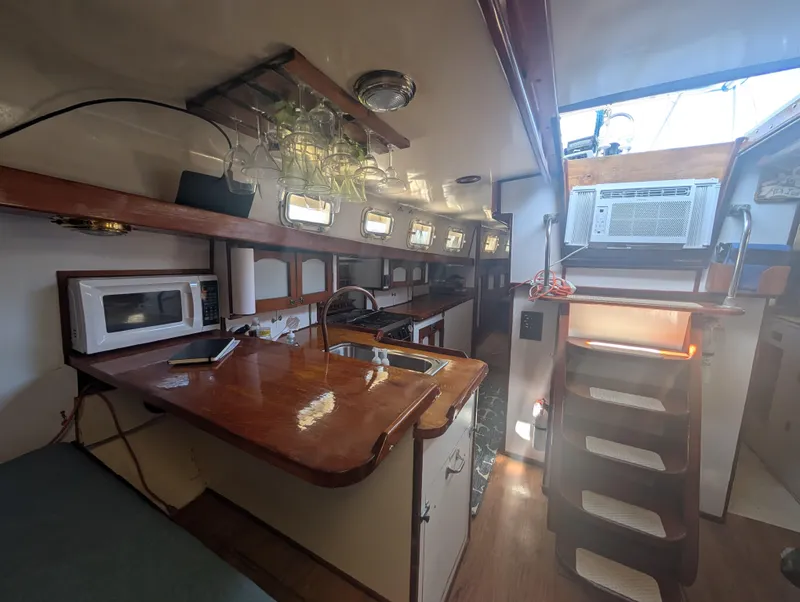 Slide: The Image of 1976 Mason COHORT II yacht interior with kitchen, microwave, and stairs. - 3