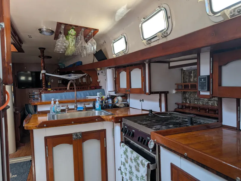 Slide: The Image of 1976 Mason COHORT II yacht kitchen with wooden cabinets, stove, and sink. - 4