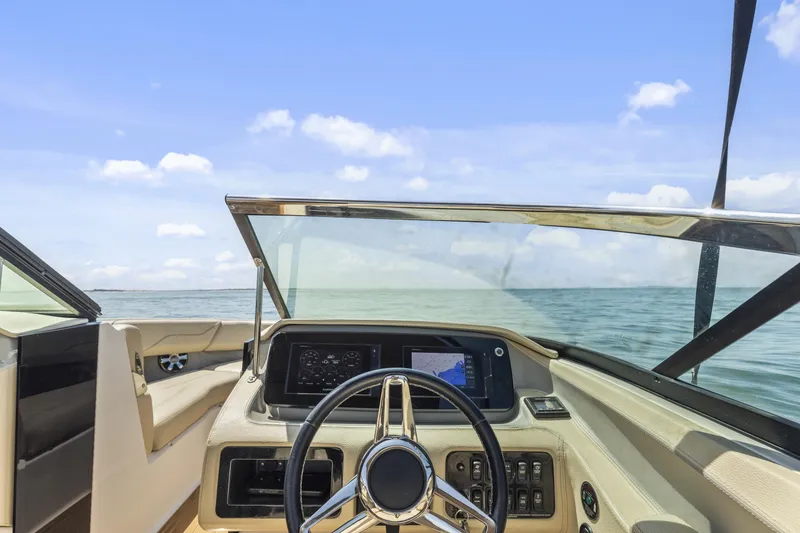 Slide: The Image of 2019 Regal LS4 boat dashboard with steering wheel, navigation screen, and ocean view. - 10