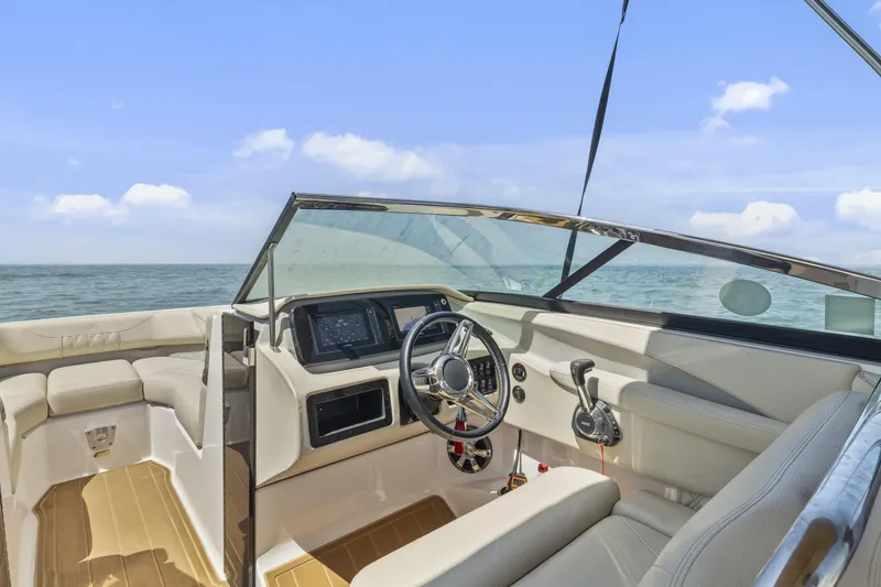 Slide: The Image of 2019 Regal LS4 boat interior with steering wheel, dashboard, and seating, on open water. - 11