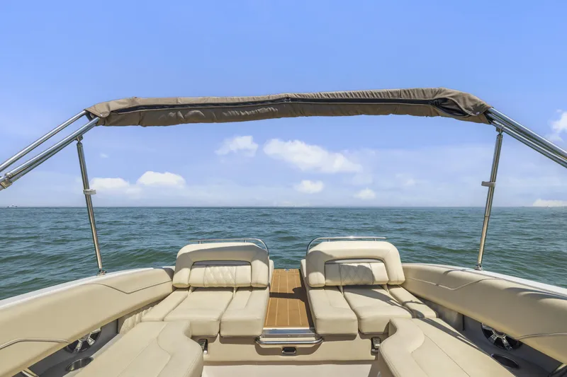 Slide: The Image of 2019 Regal LS4 boat interior with beige seating and canopy on open water. - 20