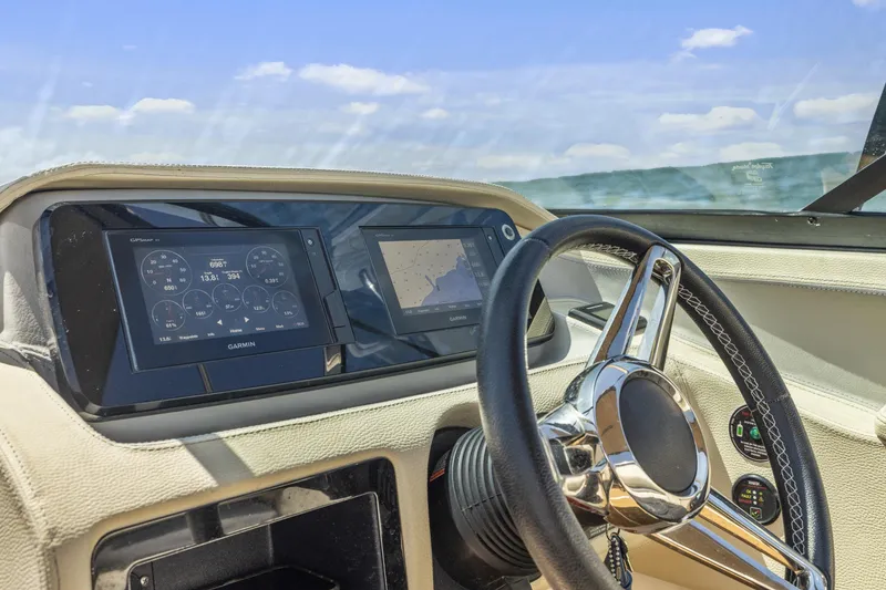 Slide: The Image of 2019 Regal LS4 boat dashboard with Garmin displays and steering wheel, ocean view. - 9