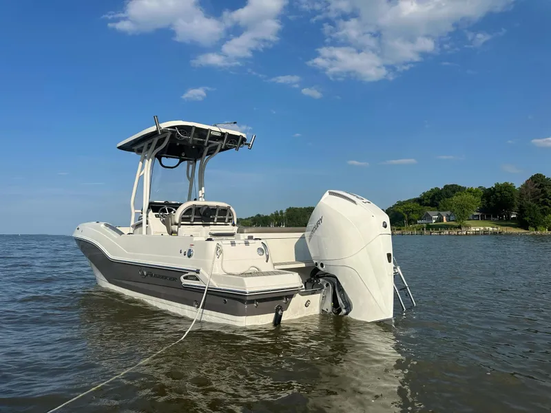 Slide: The Image of 2024 Finseeker 230 CC boat on calm water under a clear blue sky. - 0