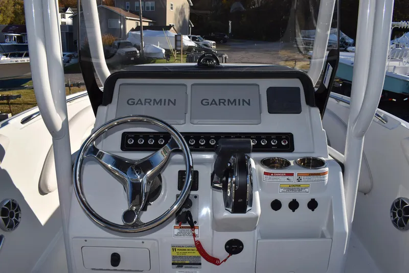Slide: The Image of 2024 Finseeker 230 CC boat dashboard with Garmin displays and steering wheel. - 2