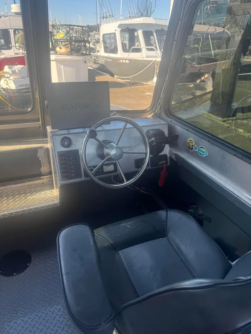 Slide: The Image of Interior of 2022 Custom Umpqua Marina 26, featuring steering wheel and Garmin navigation system. - 2