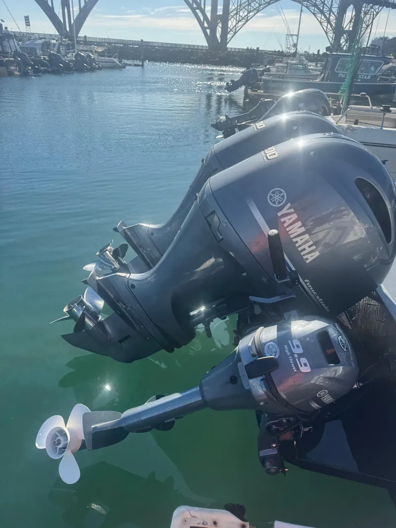 Slide: The Image of Twin Yamaha outboard motors on a 2022 Umpqua Marina 26 Bay Series boat at a marina. - 8