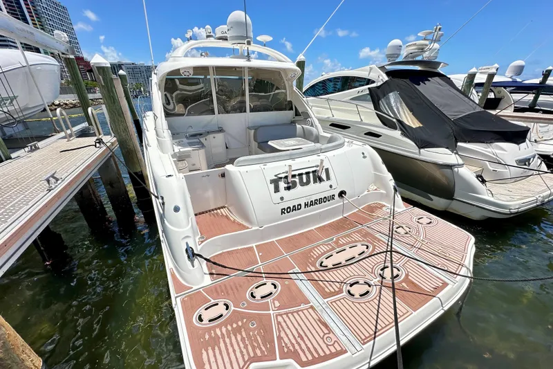 The Image of 2005 Sea Ray 48 Sundancer yacht docked at marina under clear blue sky. - 0