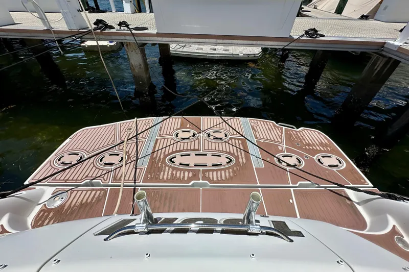 Slide: The Image of 2005 Sea Ray 48 Sundancer swim platform at dock, featuring teak decking. - 11