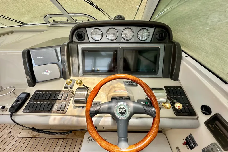 Slide: The Image of Helm of 2005 Sea Ray 48 Sundancer with wood steering wheel and dual displays. - 13