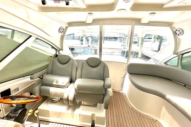 Slide: The Image of Interior of 2005 Sea Ray 48 Sundancer yacht with plush seating and wooden accents. - 15