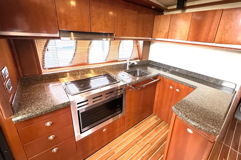 Slide: The Image of Luxurious 2005 Sea Ray 48 Sundancer yacht kitchen with wood cabinetry and granite countertops. - 17