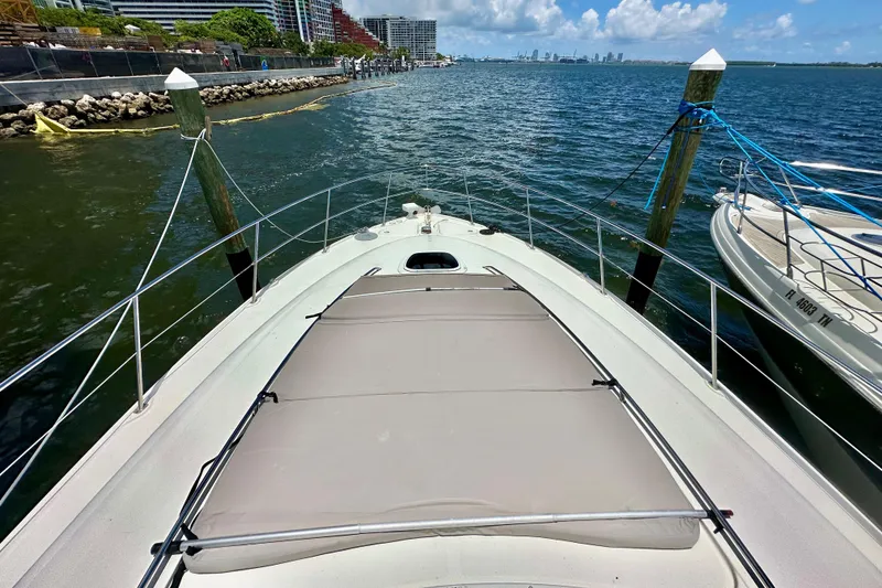 Slide: The Image of 2005 Sea Ray 48 Sundancer yacht docked by waterfront with city skyline in background. - 28