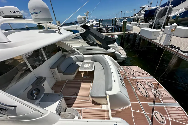 Slide: The Image of 2005 Sea Ray 48 Sundancer yacht with spacious deck and seating at marina. - 3