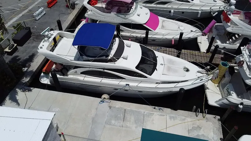 Slide: The Image of Azimut 46 yacht from 2000 docked at a marina, featuring a blue canopy. - 11