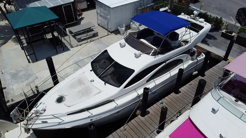 Slide: The Image of Azimut 46 yacht from 2000 docked at a marina with blue canopy. - 12