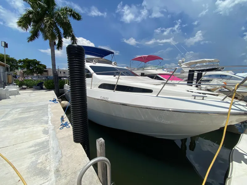Slide: The Image of Azimut 46 yacht from 2000 docked under a clear blue sky with palm trees. - 15