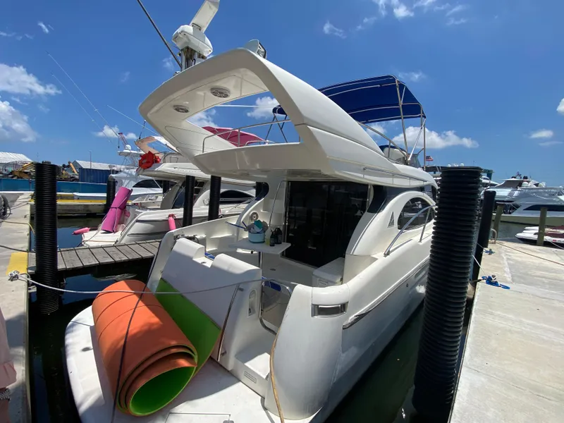 Slide: The Image of Azimut 46 yacht from 2000 docked at a marina under a clear blue sky. - 16