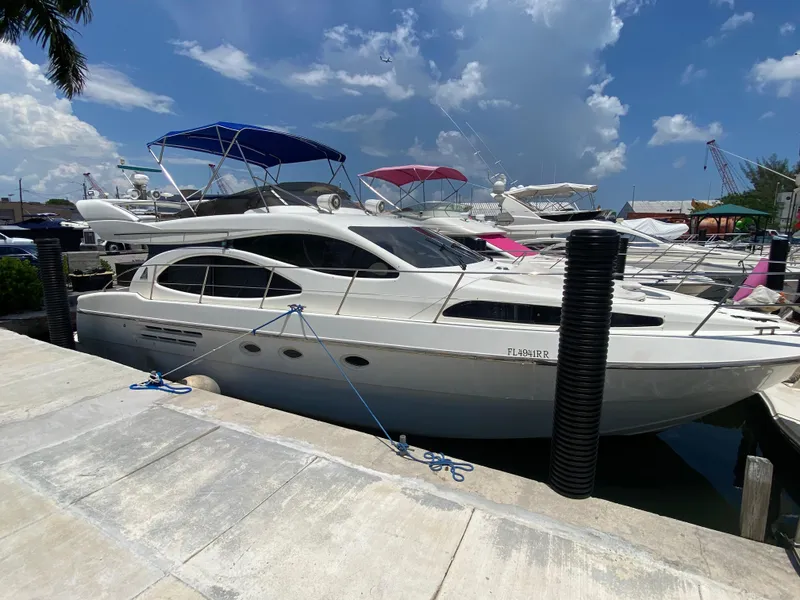 Slide: The Image of Azimut 46 yacht from 2000 docked at marina under blue sky. - 22