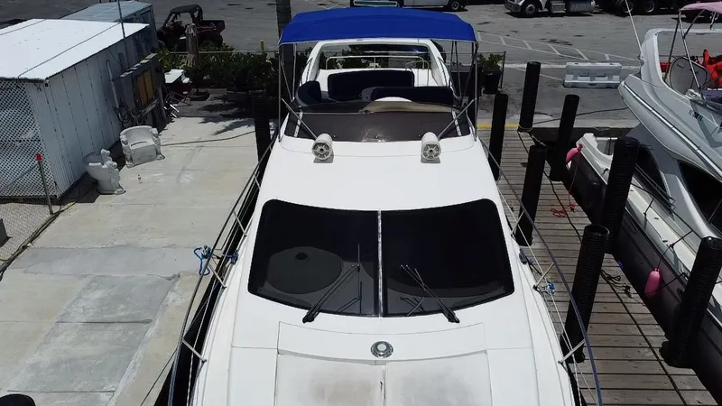 Slide: The Image of Azimut 46 yacht from 2000 docked with blue canopy and sleek design. - 23