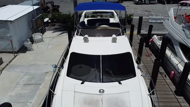 Slide: The Image of Azimut 46 yacht from 2000 docked, featuring a blue canopy and sleek design. - 24