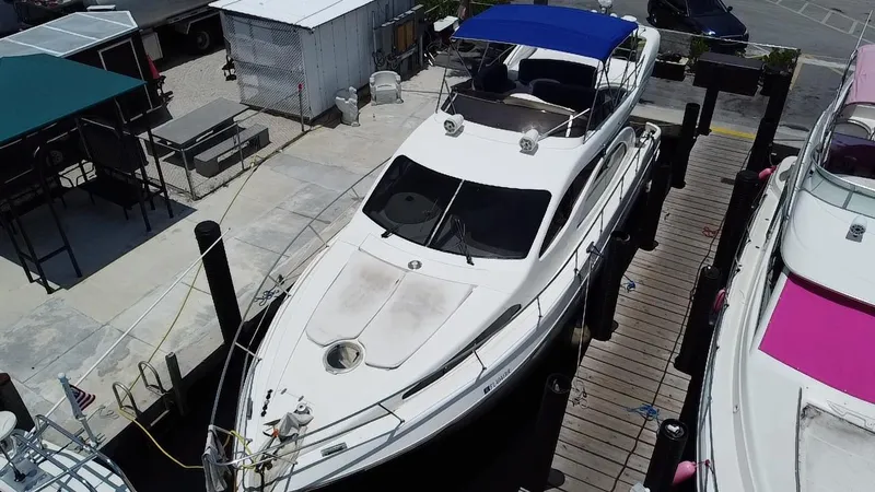 Slide: The Image of Azimut 46 yacht from 2000 docked at a marina with blue canopy. - 9