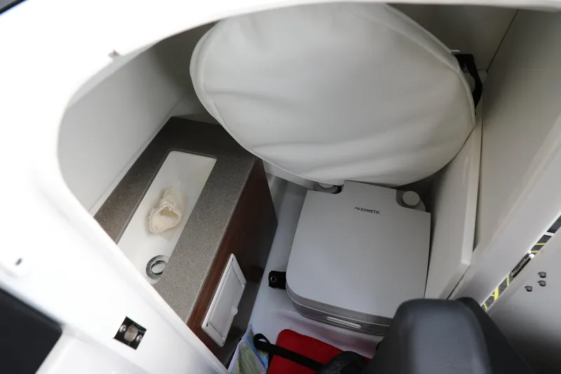 Slide: The Image of 2023 Scarab 255 ID boat interior with compact Dometic toilet and sink. - 9
