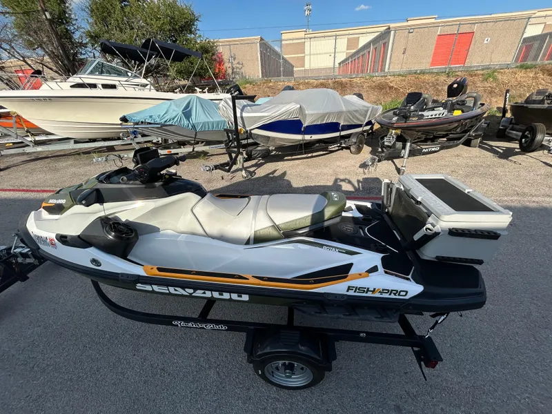 Slide: The Image of 2020 Sea-Doo FISH PRO 170 jet ski on trailer, parked near other boats. - 7