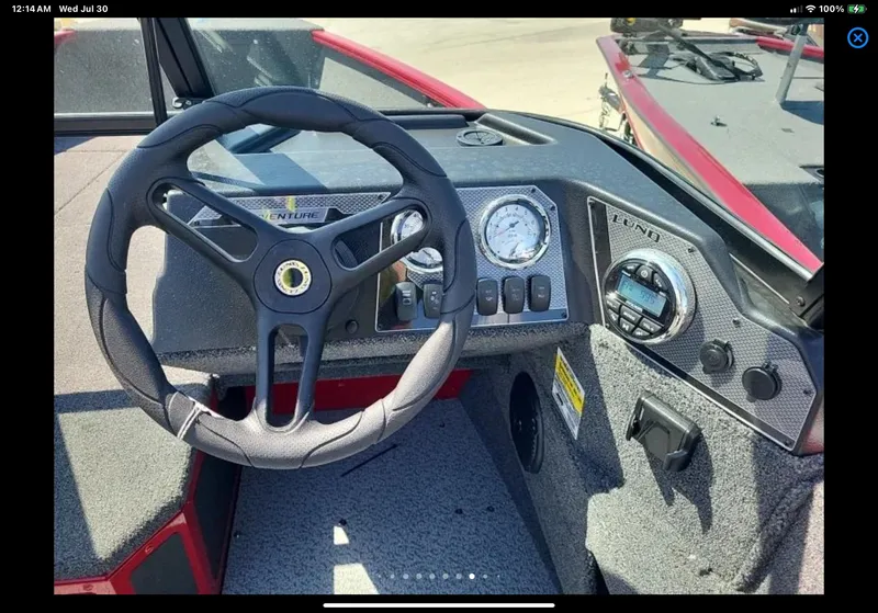 Slide: The Image of 2024 Lund 1675 Adventure Sport boat dashboard with steering wheel and control panel. - 23