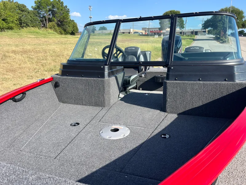 Slide: The Image of 2024 Lund 1675 Adventure Sport boat with spacious deck and windshield, parked outdoors. - 27