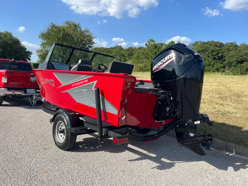 Slide: The Image of 2024 Lund 1675 Adventure Sport boat with Mercury engine, parked on a sunny day. - 33