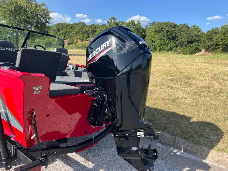 Slide: The Image of 2024 Lund 1675 Adventure Sport boat with Mercury outboard motor, parked on grass. - 34
