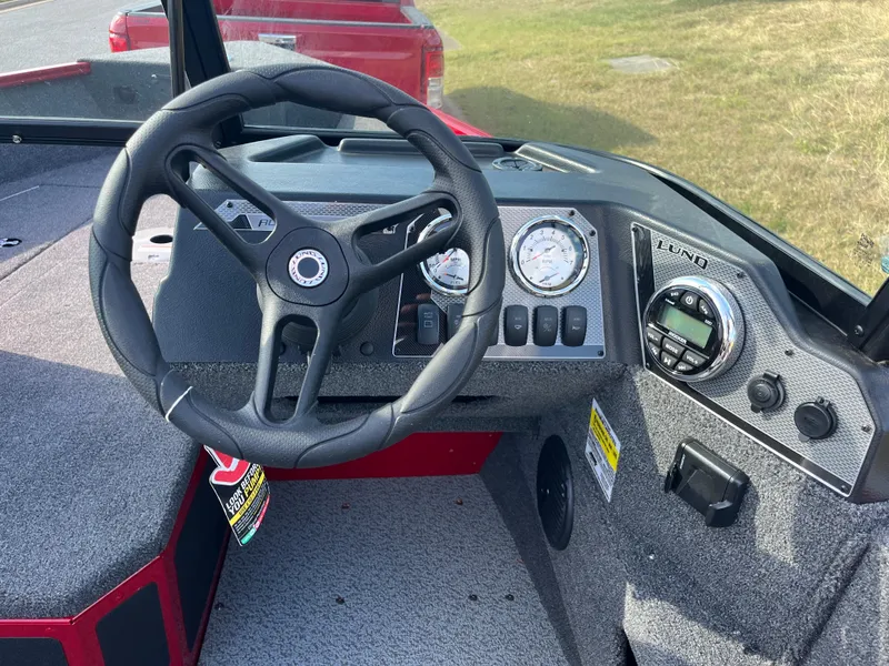 Slide: The Image of 2024 Lund 1675 Adventure Sport boat dashboard with steering wheel and gauges. - 43