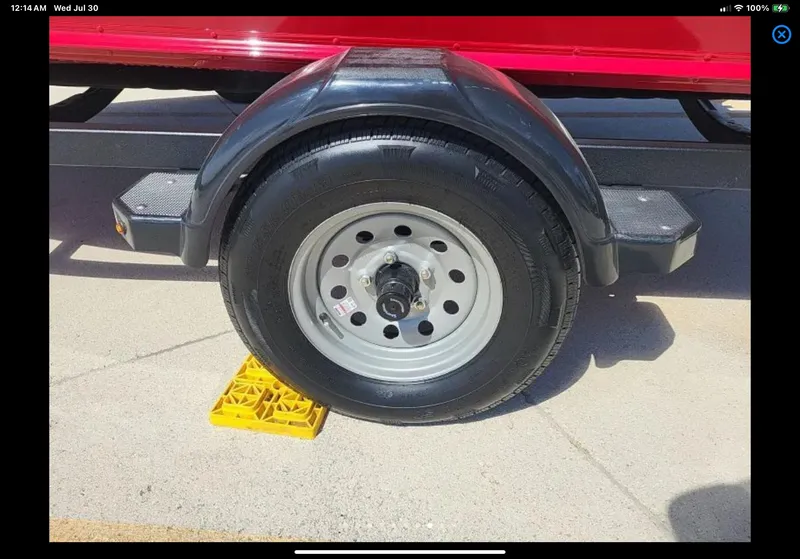 Slide: The Image of Trailer wheel of 2024 Lund 1675 Adventure Sport on yellow chock. - 9