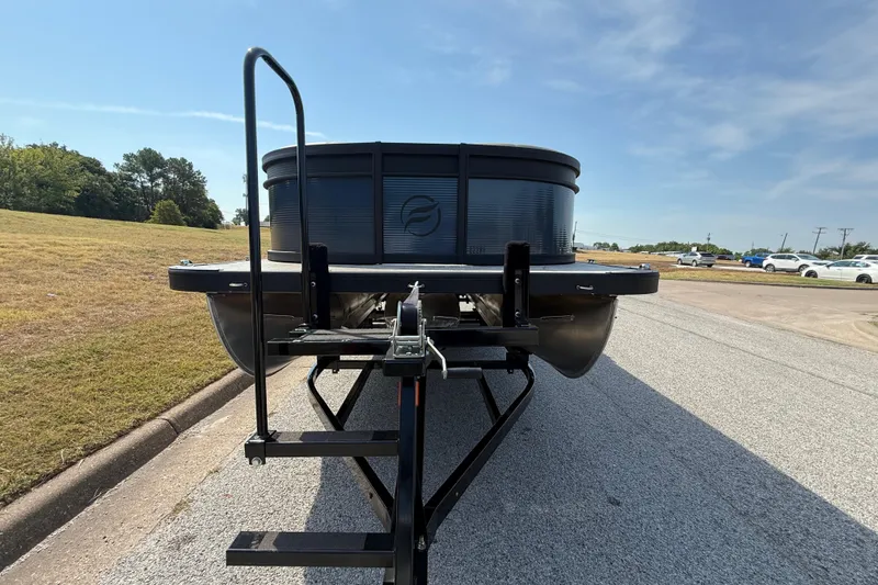 Slide: The Image of 2025 Flagship E22RF Sport Toon pontoon boat on trailer, parked on roadside. - 1