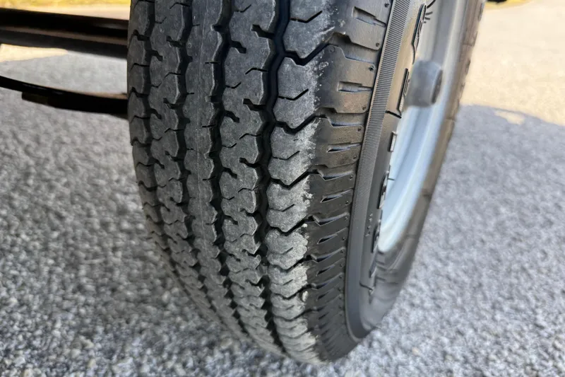 Slide: The Image of Close-up of a 2025 Flagship E22RF Sport Toon tire on a textured road surface. - 33