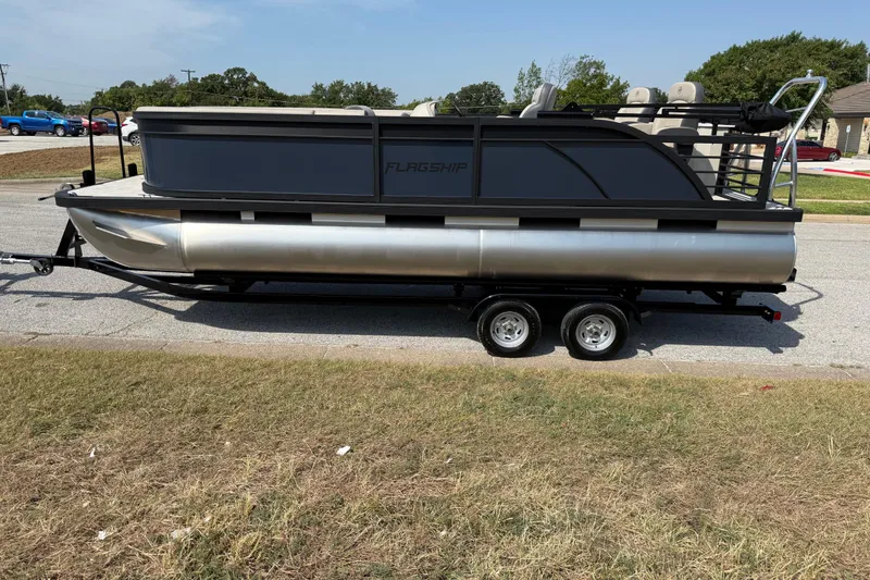 Slide: The Image of 2025 Flagship E22RF Sport Toon pontoon boat on trailer, parked on roadside. - 37