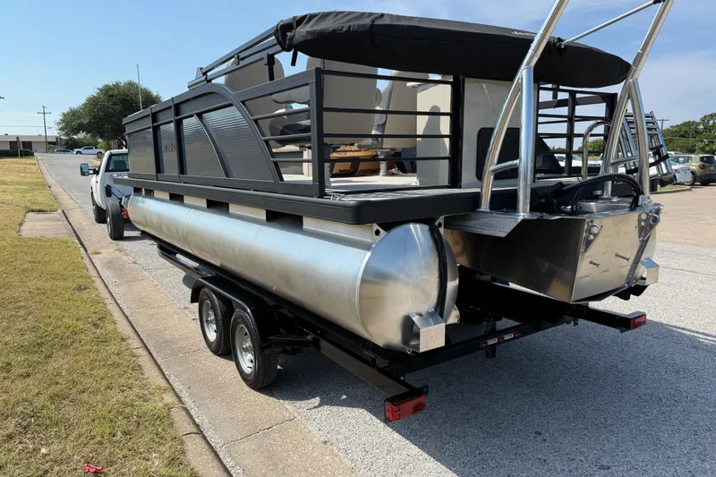 Slide: The Image of 2025 Flagship E22RF Sport Toon pontoon boat on trailer, parked on roadside. - 38