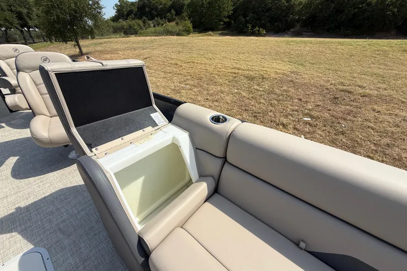 Slide: The Image of 2025 Flagship E22RF Sport Toon boat with open storage compartment and beige seating. - 45