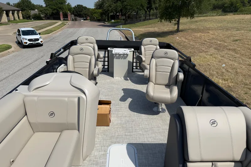 Slide: The Image of 2025 Flagship E22RF Sport Toon boat with beige seating on a street. - 56